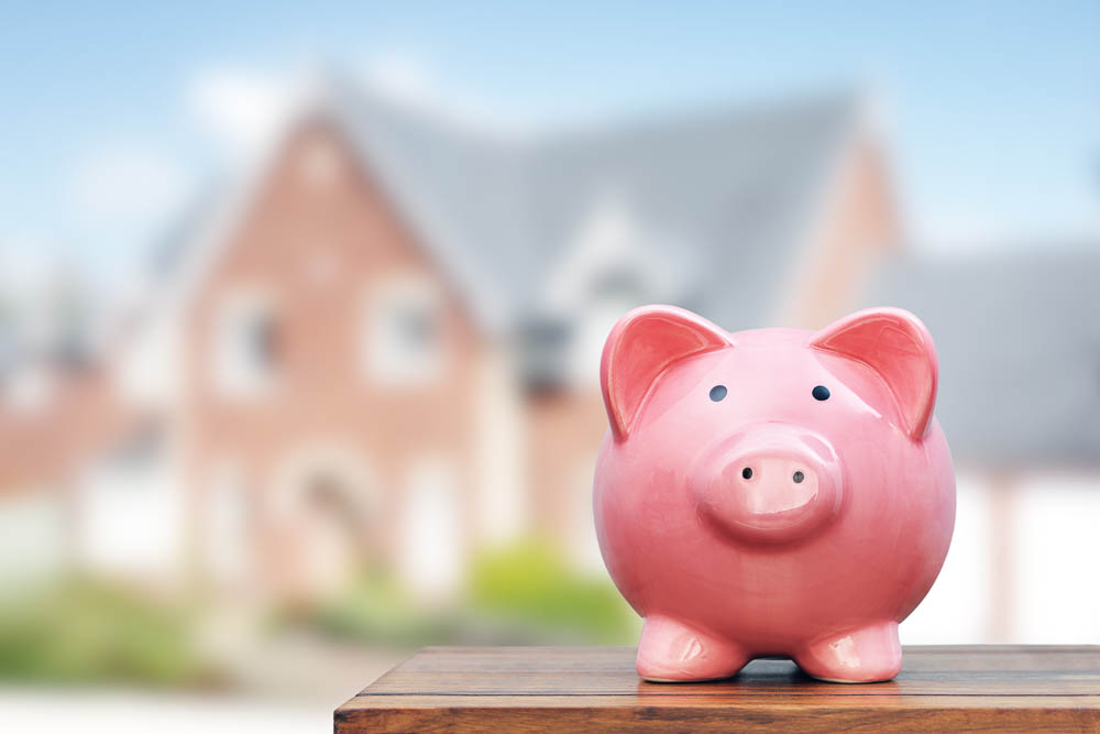 Saving to buy a house, real estate or home savings, piggy bank in front of property